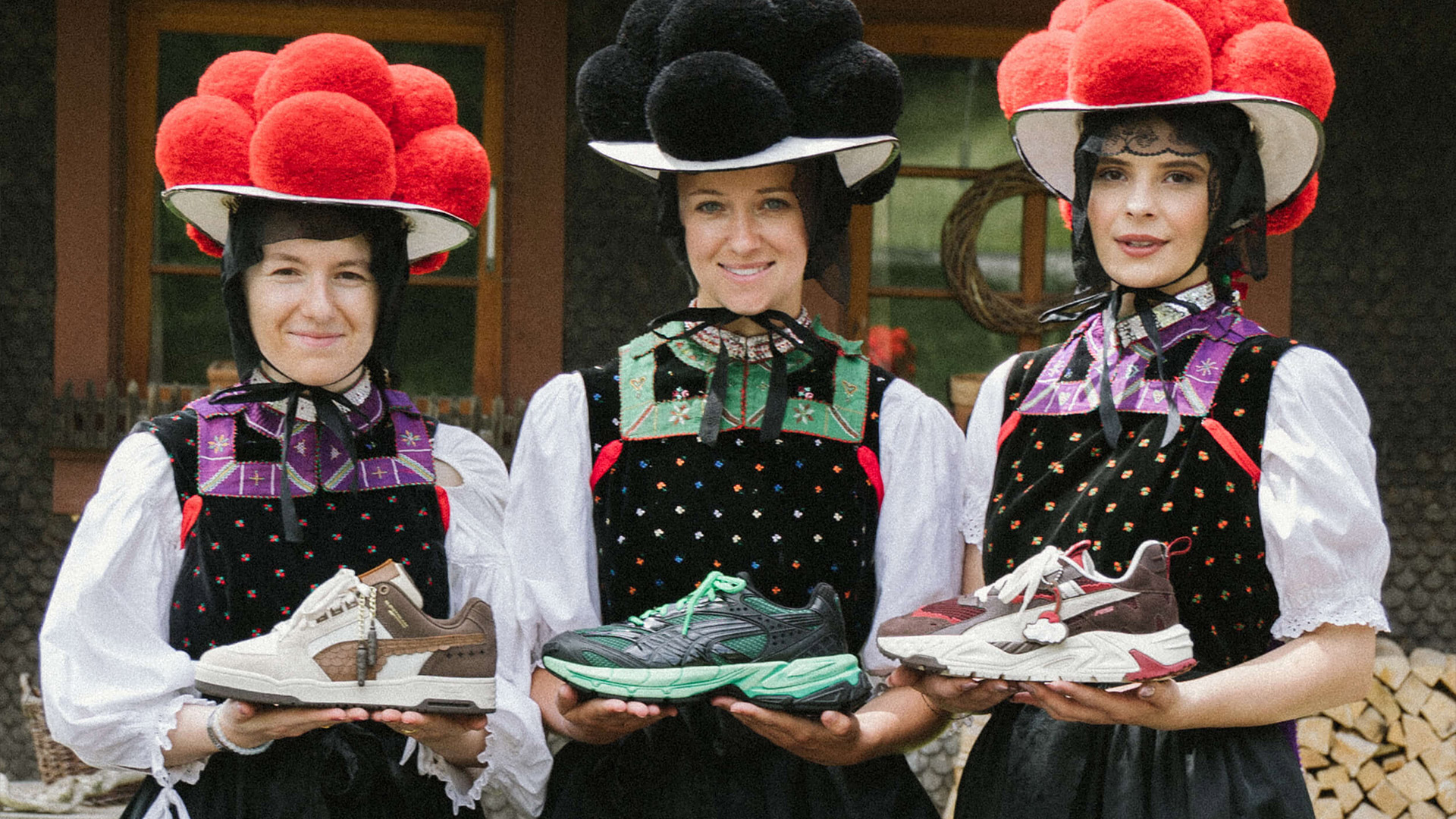 Drei Frauen in traditioneller Schwarzwald-Tracht halten lächelnd 3 verschiedene Puma-Sneaker in die Kamera.