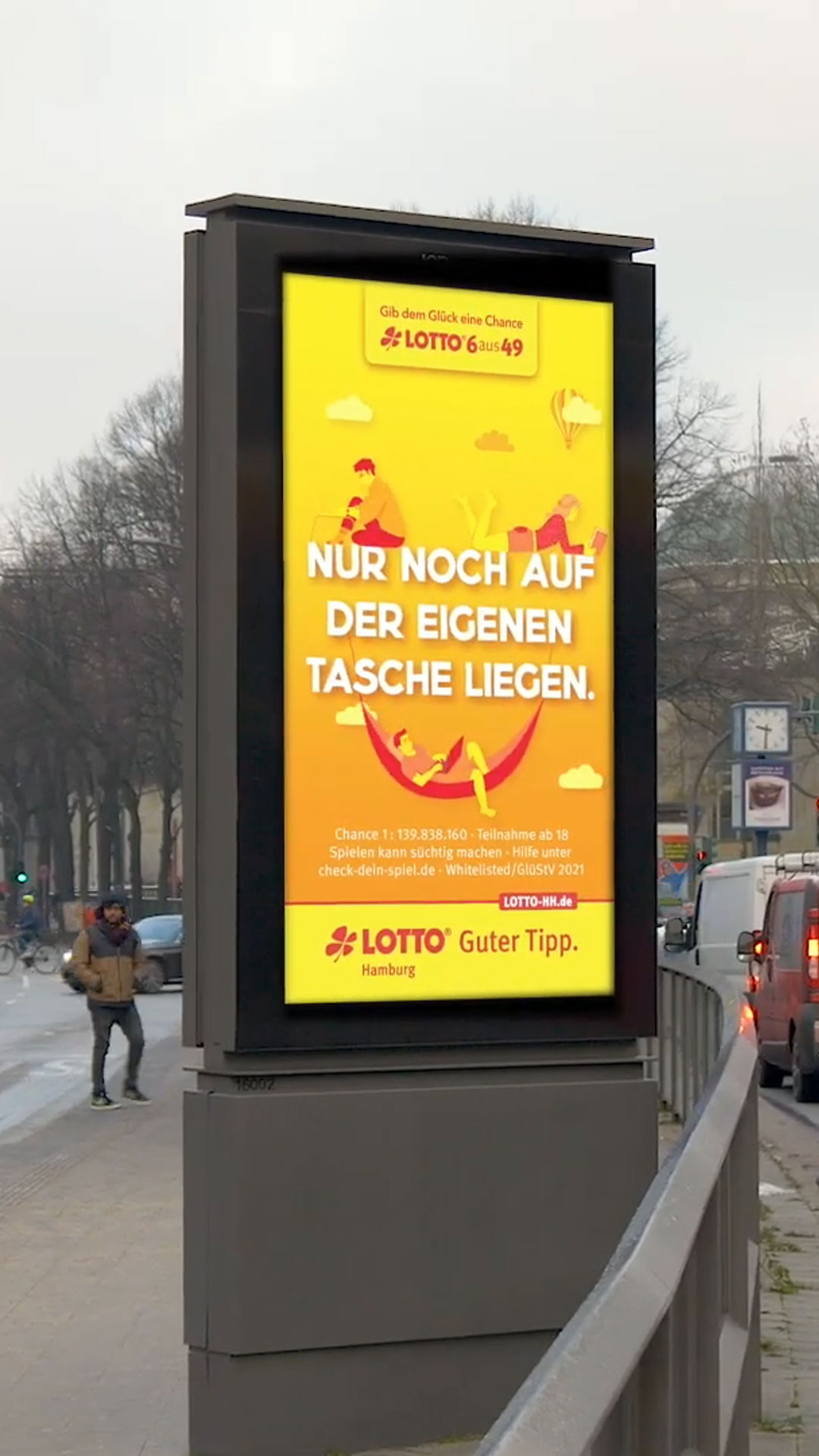 Zu sehen ist ein Citylight Bildschrim an einer Straße. Es zeigt ein Lotto-Plakat mit der Überschrift: "Nur noch auf der eigenen Tasche liegen."